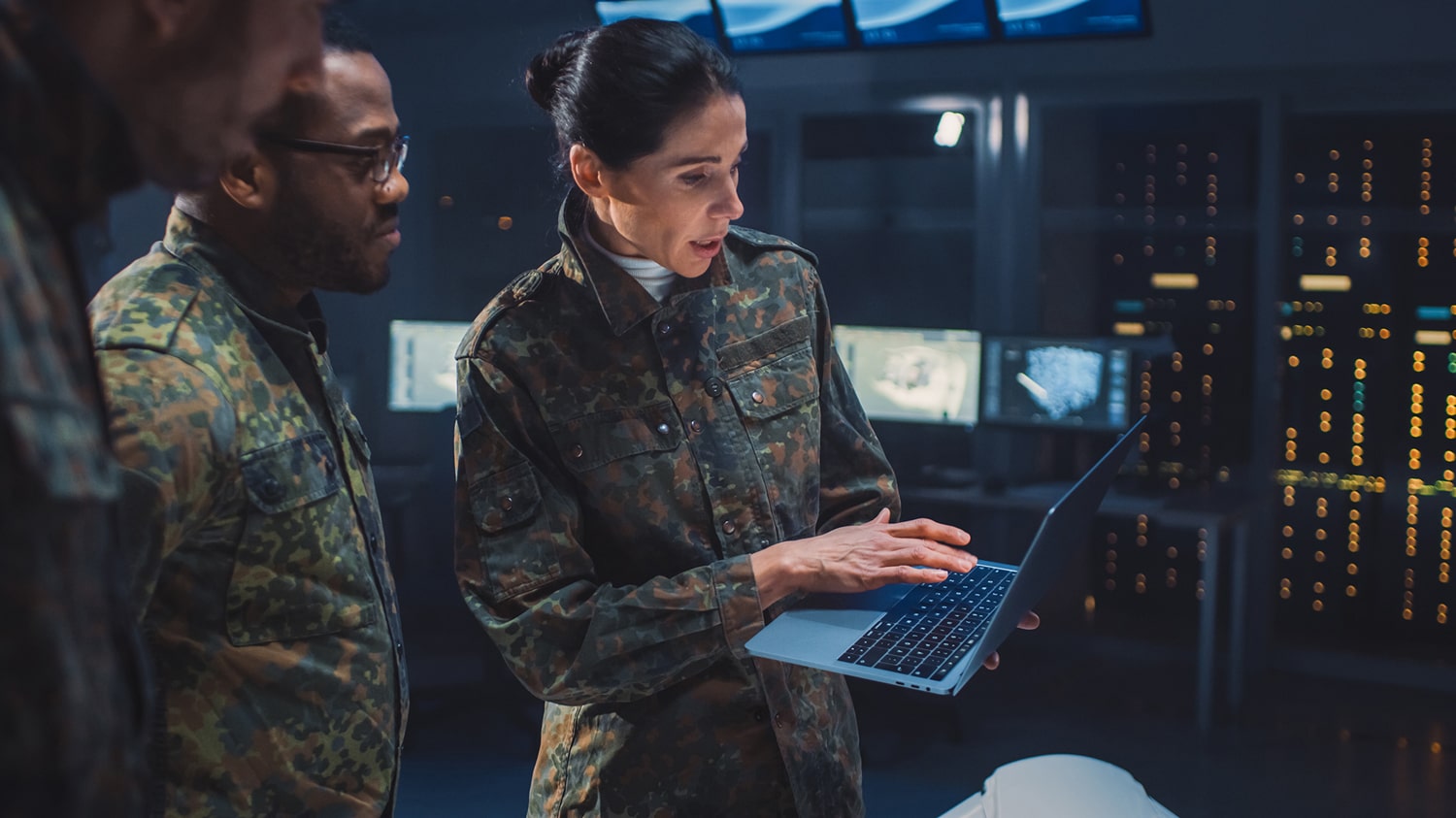 Picture of two men and a woman in uniform looking at a computer